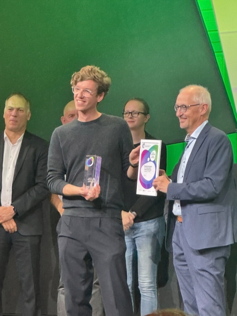 Award-Gewinner mit Trophäe und Urkunde auf der SCCON in Berlin